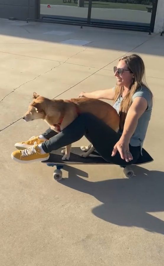 Laure sitzt mit Lina vor sich auf einem Skateboard, auf einem Platz in Kroatien