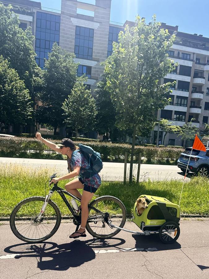 Laure auf dem Rad auf einer Straße in Frankreich, Lina sitzt im Anhänger dahinter